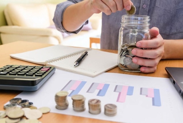 man putting money in a jar